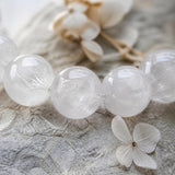 Close-up of natural Milky Quartz crystal beads showing cloudy white translucency - World of Oorja