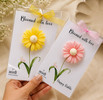 Bloomed With Love Rakhi flower candles in yellow and pink on Happy Rakhi gift cards with ribbon bows
