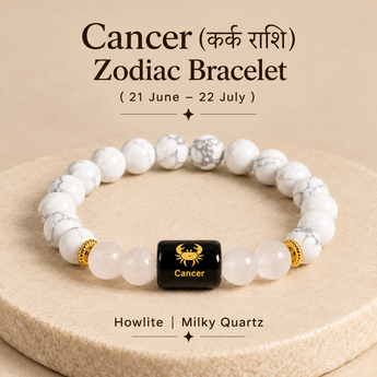 A Cancer zodiac bracelet made of white and gray marbled howlite and milky quartz beads, with a central black cube bead featuring a gold Cancer zodiac symbol and text. The bracelet is displayed on a beige textured pedestal with astrological text above and below.