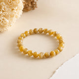 Cats Eye Lehsunia bracelet with honey-gold chatoyant beads on a cream backdrop with dried flowers – World of Oorja