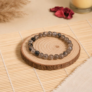 Dragon Vein agate bracelet with translucent grey-white crackle-veined beads on a rustic wood slice with pampas – World of Oorja
