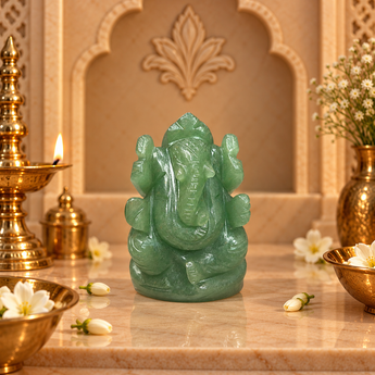 Green Aventurine Ganesh Ji murti in soft mint green on a marble altar with brass diya