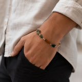 Hand wearing Raw Dhan Yog bracelet with natural uncut crystals - wealth attraction crystal bracelet