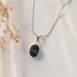 Sulemani Hakik pendant in Classic bezel setting on silver chain — banded black agate front view