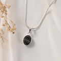 Sulemani Hakik pendant in Classic bezel setting on silver chain — banded black agate front view