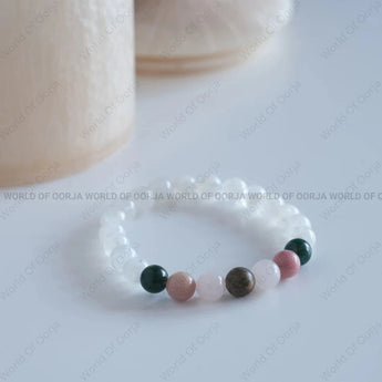Beaded bracelet with multicolored beads on a white surface, branded 'World of Oorja'.