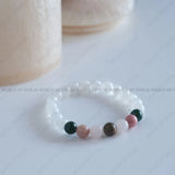 Beaded bracelet with multicolored beads on a white surface, branded 'World of Oorja'.