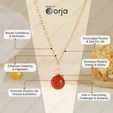 Necklace with a red pendant on a mannequin, featuring Orja brand, with text about its benefits.