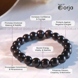Black beaded bracelet with text highlighting its benefits on a white background, branded 'World of Orja'.