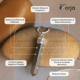 Silver pendant with text highlighting its benefits on a blurred background