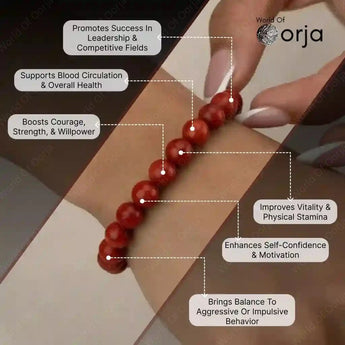 Red beaded bracelet on wrist with health benefits text and 'World of Orja' branding.
