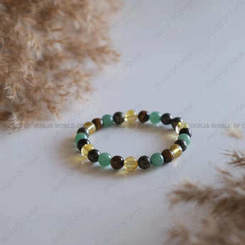 Beaded bracelet on a white surface with blurred natural background