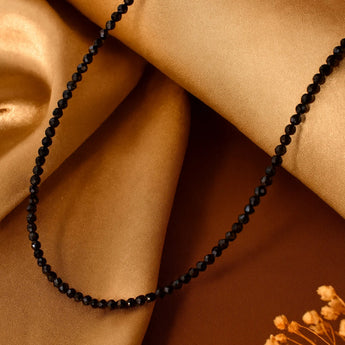 Black Spinel beaded necklace on a cloth with a brown fabric background