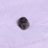 Tumbled purple stone on a white background