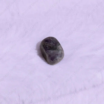 Tumbled purple stone on a white background