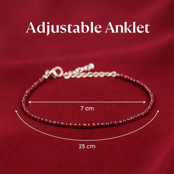 Garnet beaded anklet with adjustable chain on a red background
