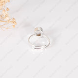 Clear glass bottle with silver cap on a light gray background