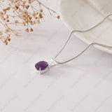 Silver necklace with a purple gemstone pendant on a light background