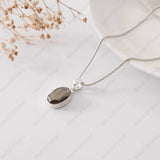Silver necklace with a smoky pendant on a light background