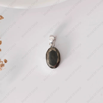 Silver pendant with a dark stone on a white background