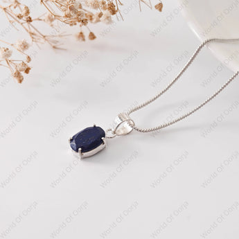Silver necklace with a blue pendant on a light background