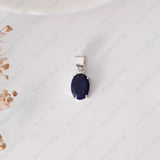 Silver pendant with a blue stone on a white background