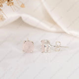 Silver stud earrings with a clear gemstone on a white background