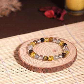 Beaded bracelet on a wooden coaster with a candle in the background