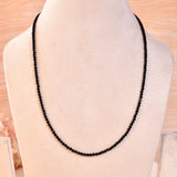 Black spinel beaded necklace on a light background