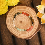 Colorful beaded bracelet on a wooden surface with yellow flowers