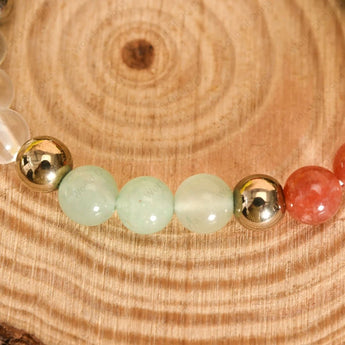 Beaded bracelet with gold and multicolored beads on a wooden surface