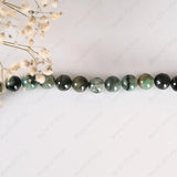 Necklace with green and black beads on a white background