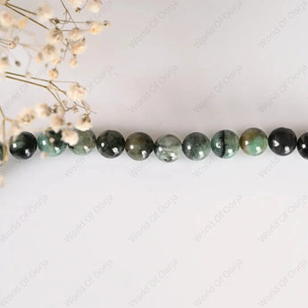 Necklace with green and black beads on a white background