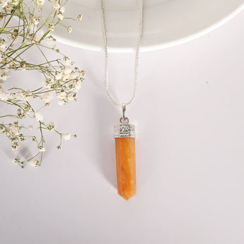 Necklace with a orange crystal pendant on a white background