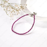 Purple beaded bracelet with silver clasp on a white background