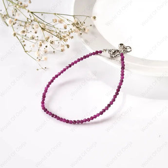 Purple beaded bracelet with silver clasp on a white background