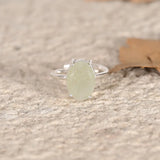 Silver ring with a green Jade stone on a textured surface