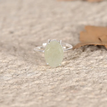 Silver ring with a green Jade stone on a textured surface