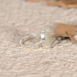 Silver ring with a green Jade stone on a textured surface