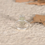 Silver ring with a green Jade stone on a textured surface
