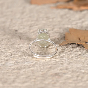 Silver ring with a green Jade stone on a textured surface