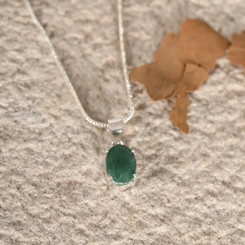 Green aventurine pendant on a textured surface