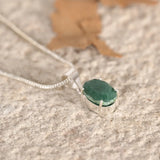 Green aventurine pendant on a textured surface