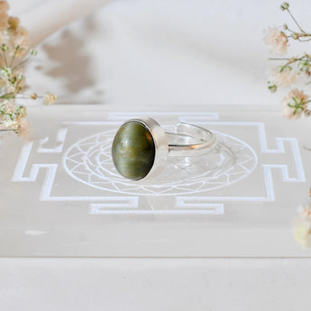 Silver ring with a cats eye stone on a burgundy fabric background