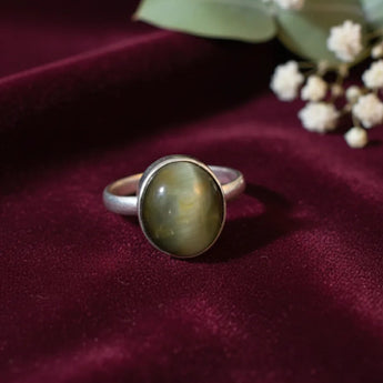 Silver ring with a cats eye stone on a burgundy fabric background