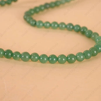 Green beaded necklace on a beige background