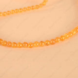 Necklace with orange beads on a beige background