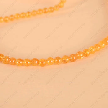 Necklace with orange beads on a beige background