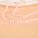 Pink beaded necklace on a beige background