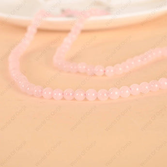 Pink beaded necklace on a beige background
